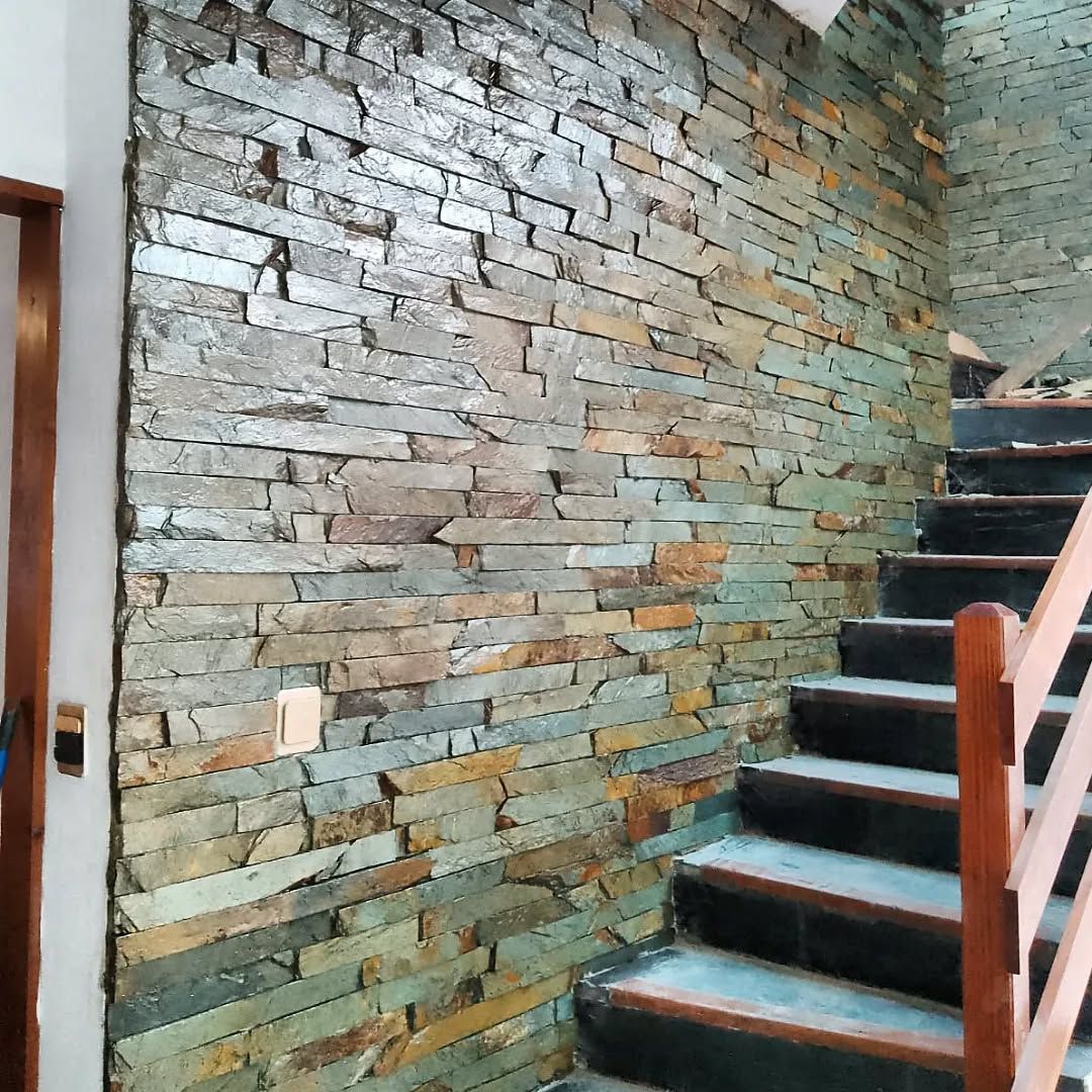 Una escalera con una pared de ladrillos detrás y una barandilla de madera.