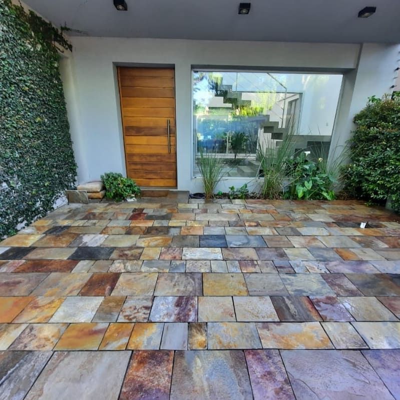 Una pasarela de ladrillos frente a una casa con una puerta de madera