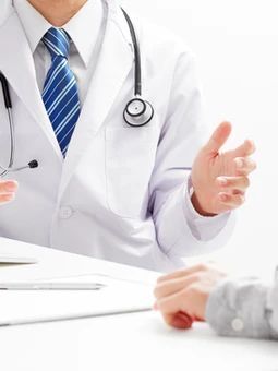 A doctor is talking to a patient with a stethoscope around his neck.