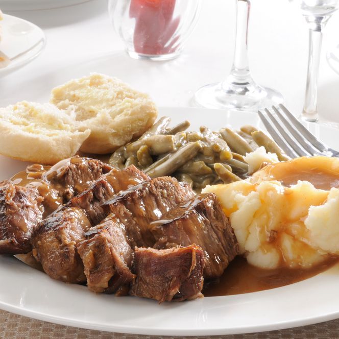 a white plate topped with meat mashed potatoes green beans and gravy