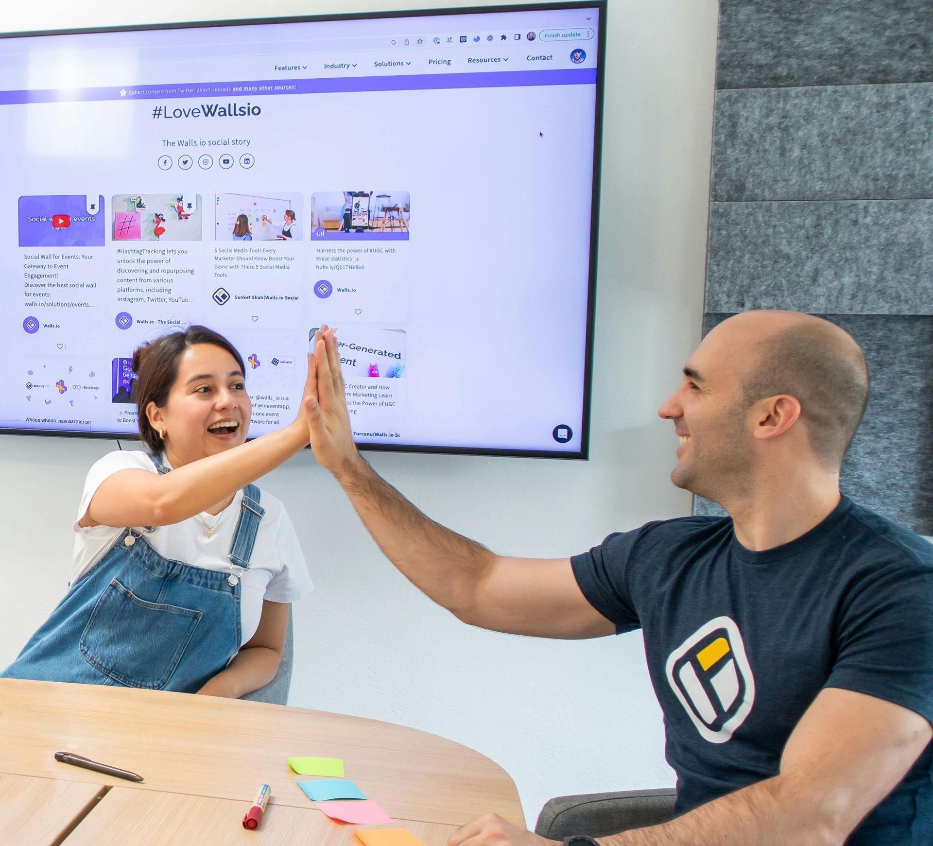 A man and a woman are giving each other a high five