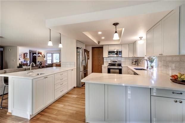 A kitchen with white cabinets and a large island