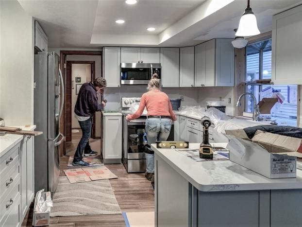 A man and a woman are working in a kitchen.