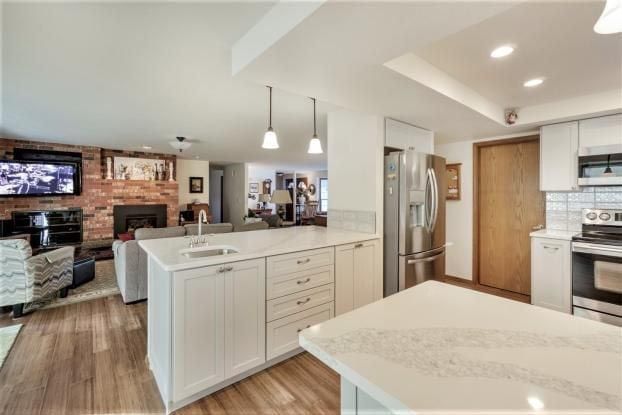 A kitchen with white cabinets and a large island in the middle