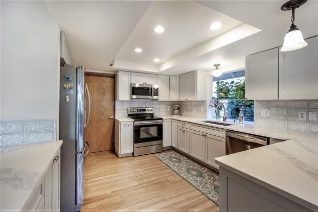 A kitchen with stainless steel appliances and white cabinets.