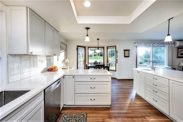 A kitchen with white cabinets and stainless steel appliances