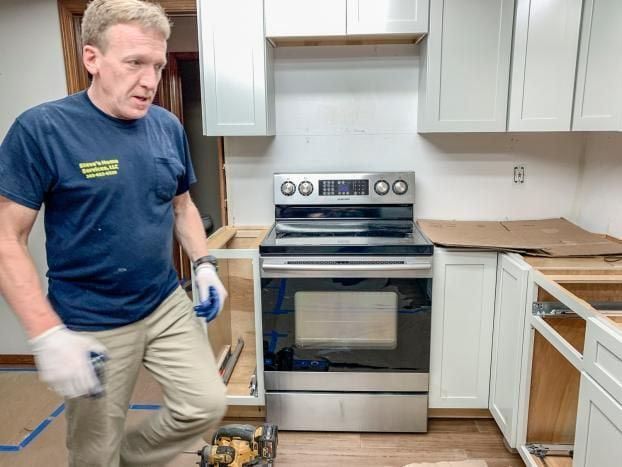 A man in a blue shirt is working in a kitchen