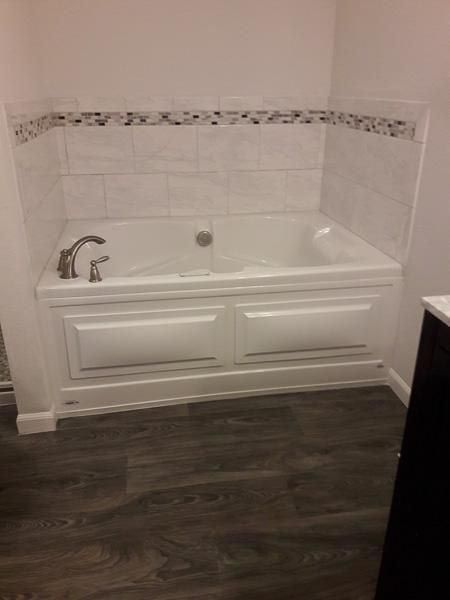 A bathtub is sitting in a bathroom next to a sink.