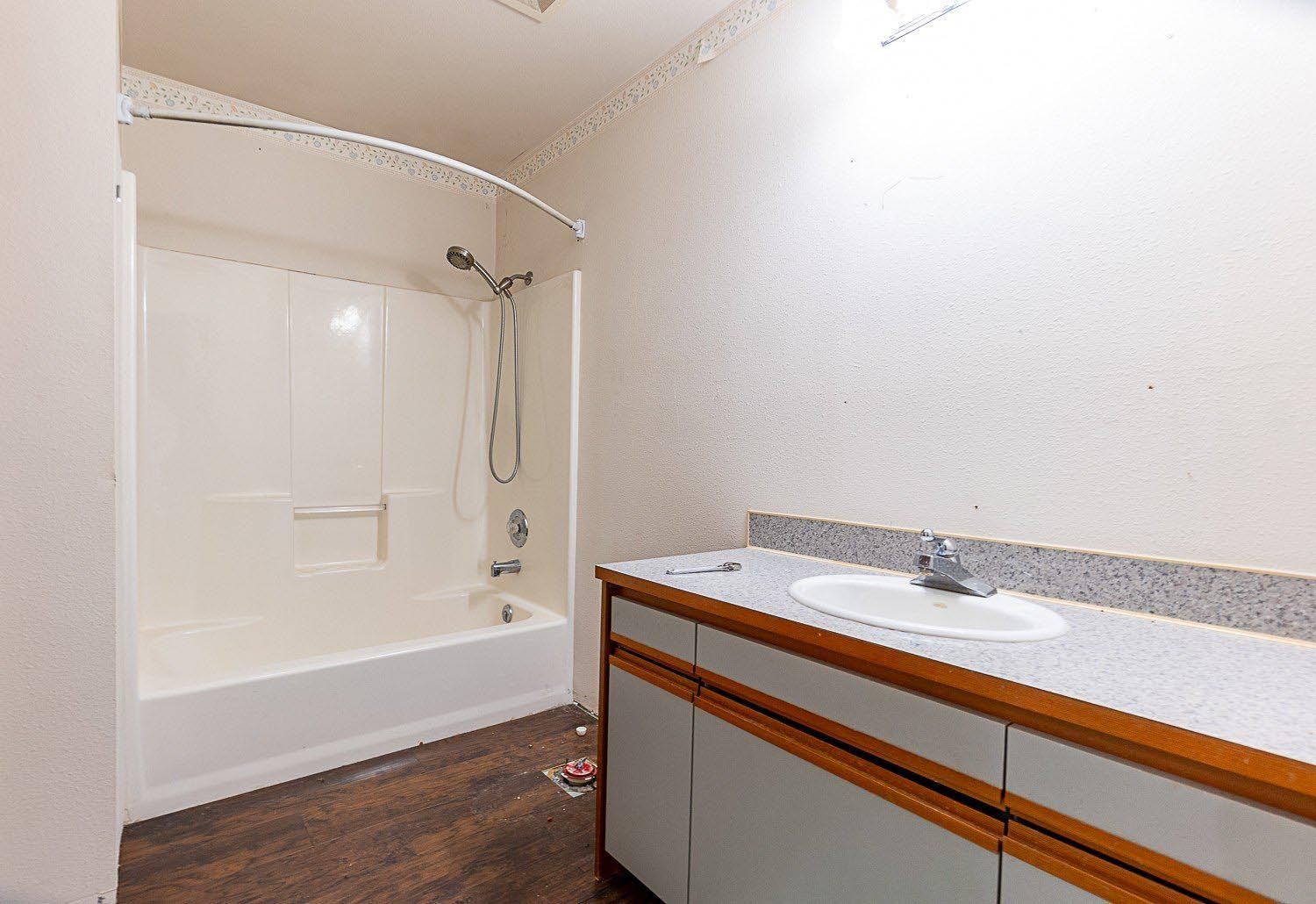 A bathroom with a sink , tub and shower.