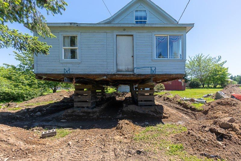 A house is being moved to a new location on stilts.