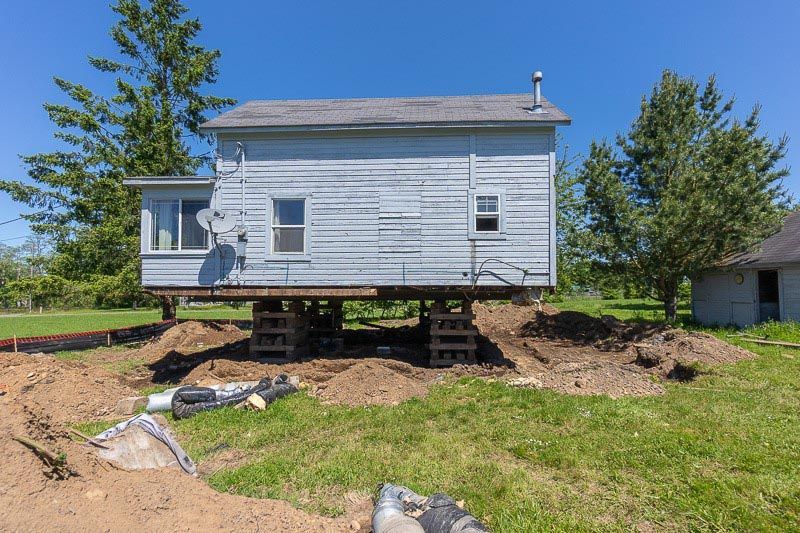 A house is being moved into a new location on stilts.