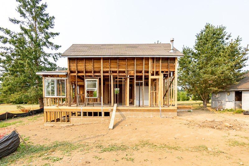 A house is being built in the middle of a dirt field.