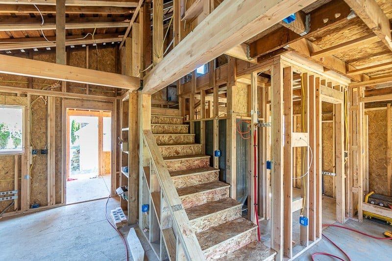 A house is being built with wooden beams and stairs.