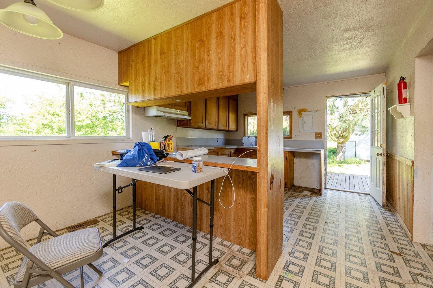 A kitchen with a table and chairs and a fire extinguisher.
