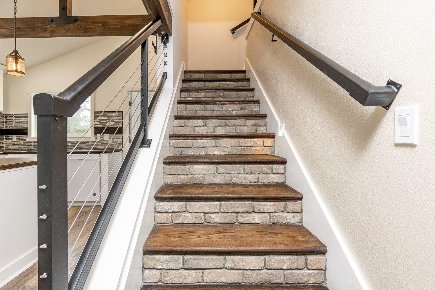 The stairs are made of wood and brick and have a metal railing.