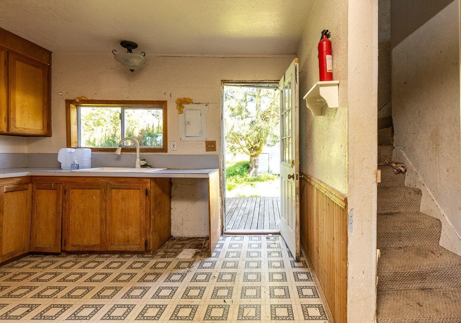 A kitchen with wooden cabinets and a fire extinguisher on a shelf