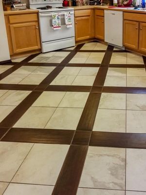 A kitchen with a tiled floor and wooden cabinets