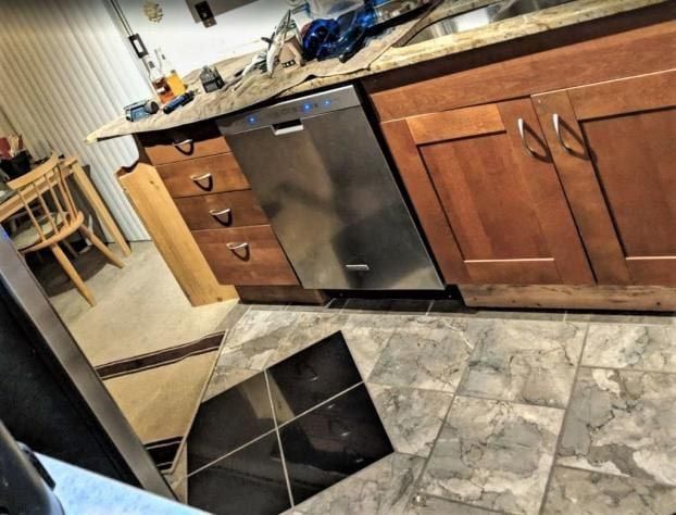 A kitchen with wooden cabinets and a stainless steel dishwasher
