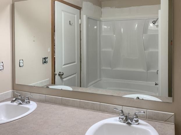 A bathroom with two sinks and a large mirror