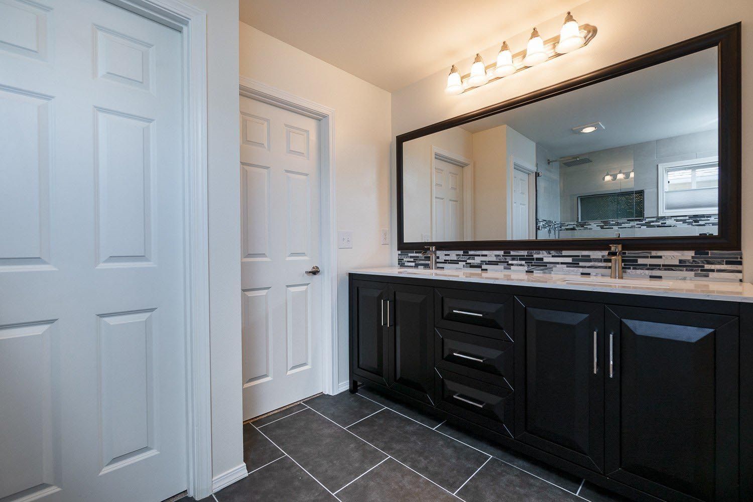 A bathroom with two sinks and a large mirror.