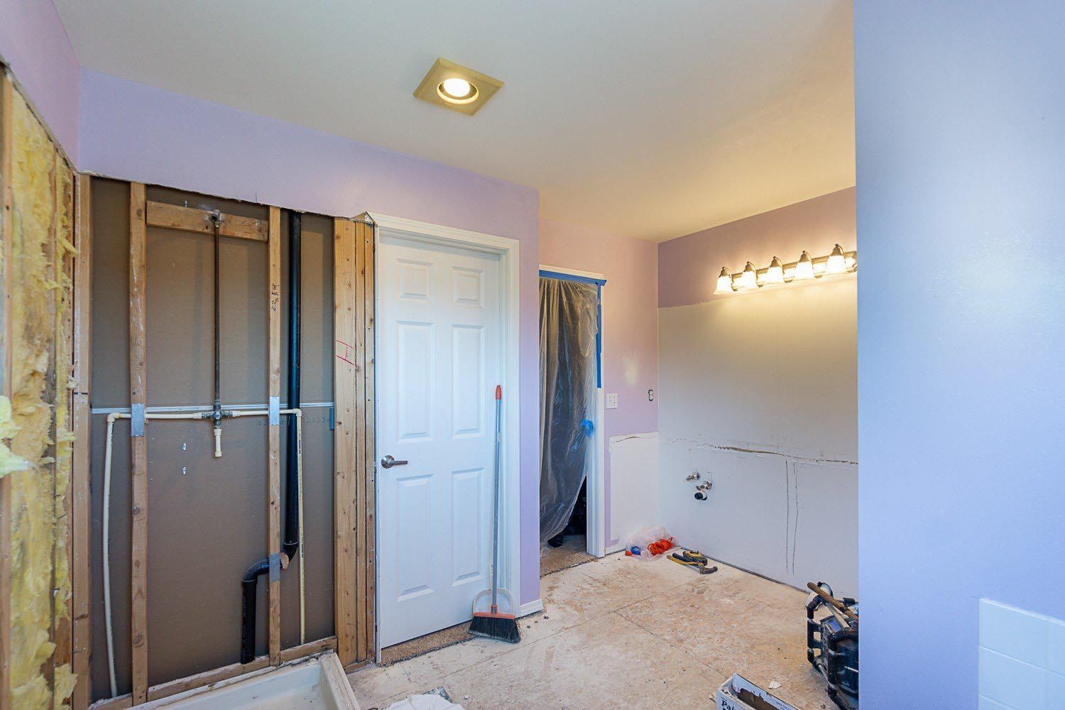 A bathroom under construction with a bathtub and a door.