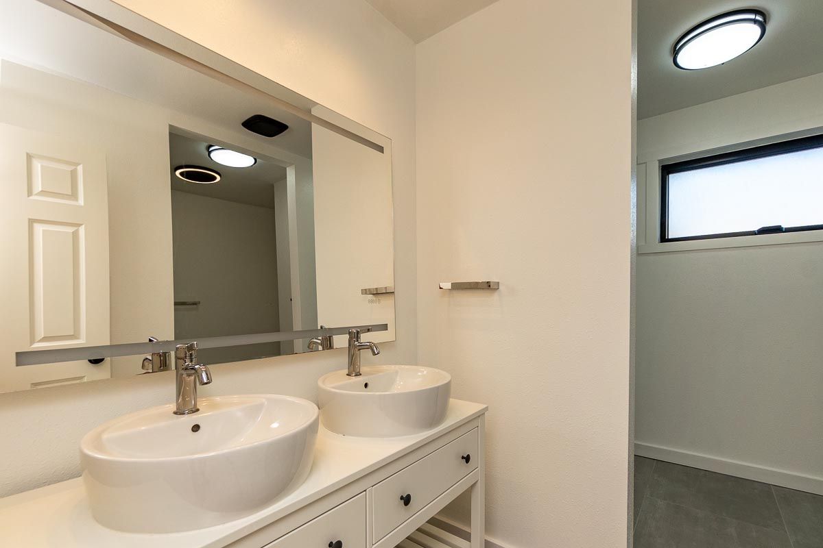 A bathroom with two sinks and a mirror.