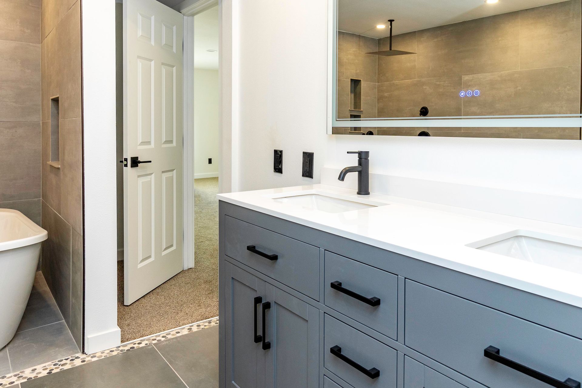 A bathroom with two sinks , a mirror and a tub.