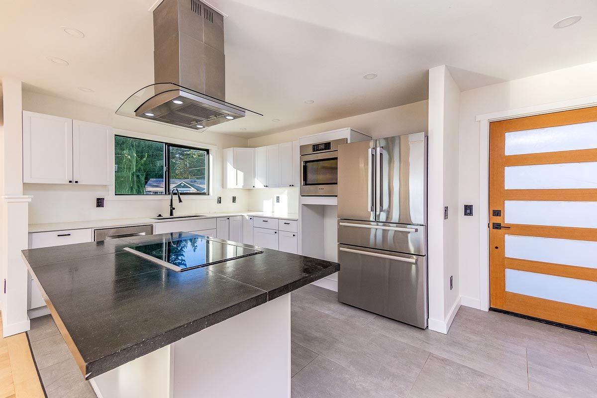 A kitchen with stainless steel appliances and a large island.