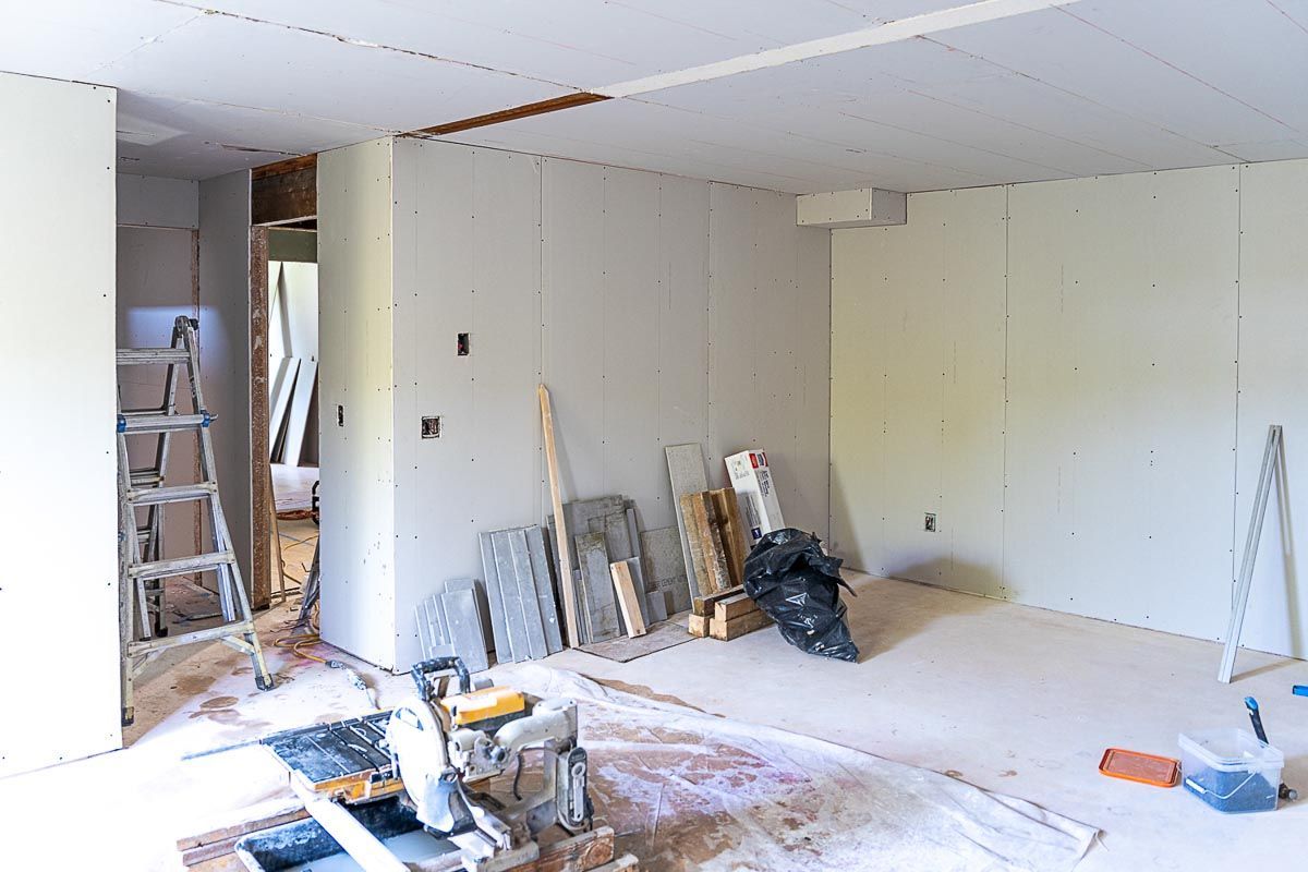 A room is being remodeled with drywall and a ladder.