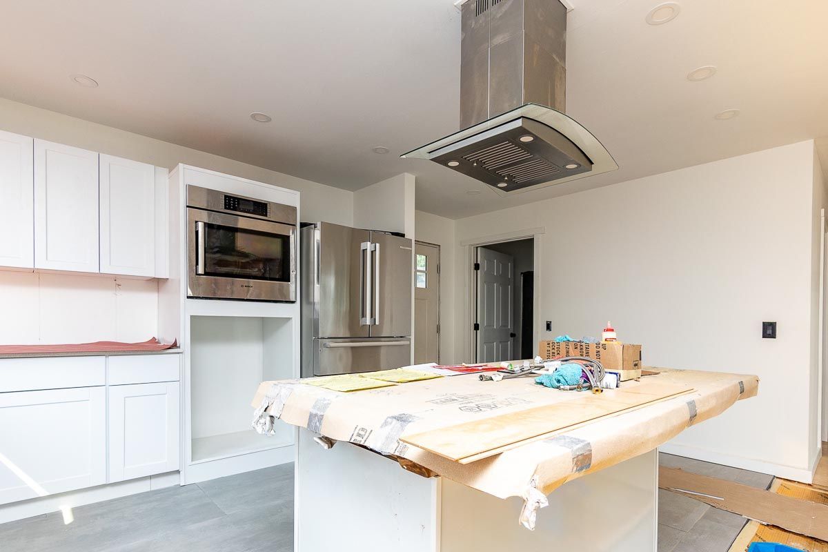 A kitchen under construction with a large island in the middle.