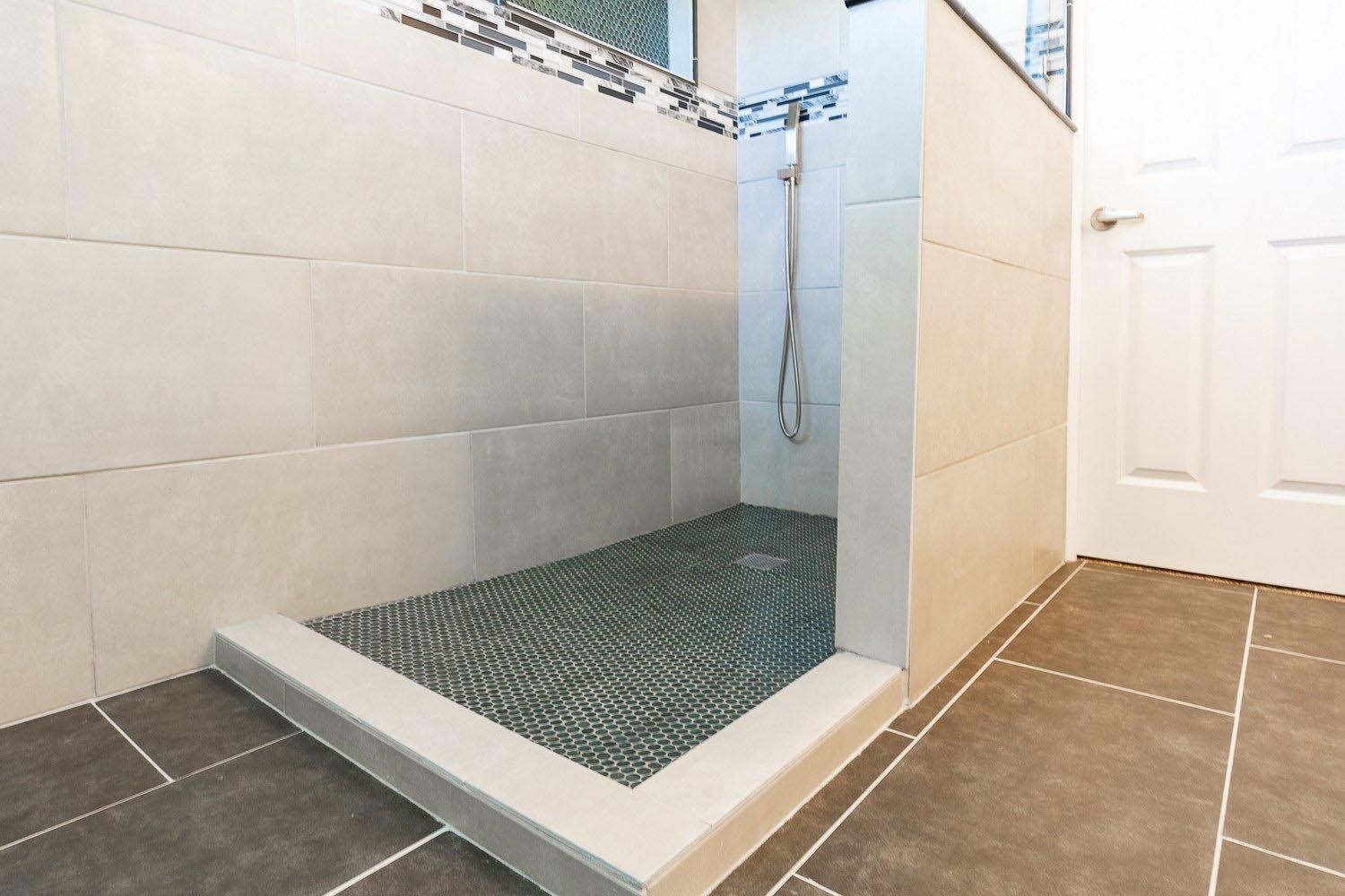 A bathroom with a walk in shower and a tiled floor