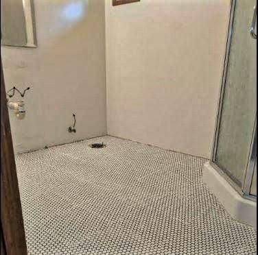 A bathroom with a shower stall and a toilet.