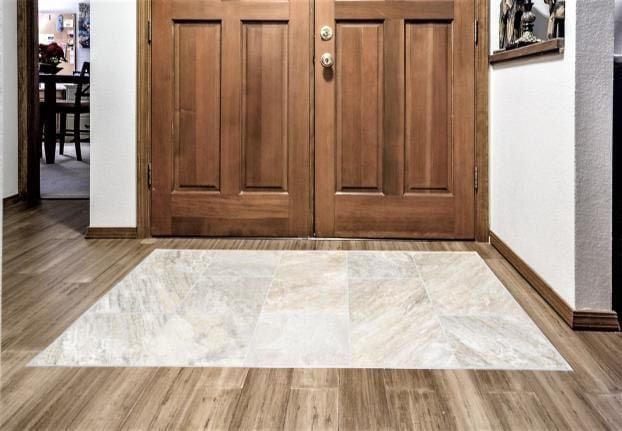 A hallway with a wooden door and a tile floor.