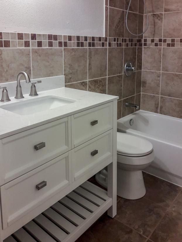 A bathroom with a sink toilet and bathtub