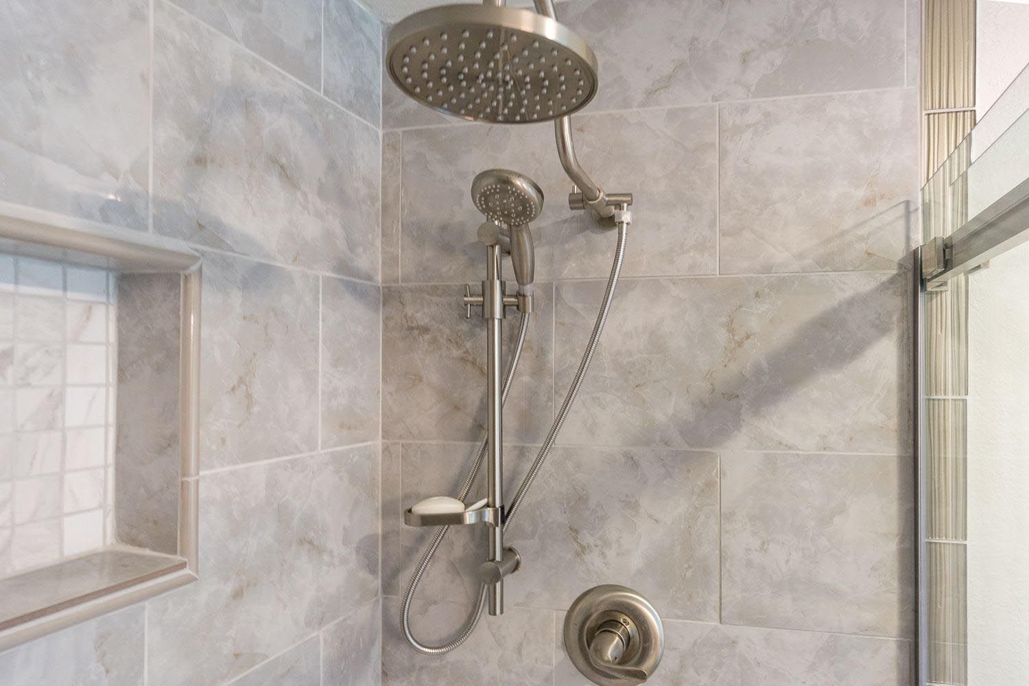 A close up of a shower head in a bathroom.