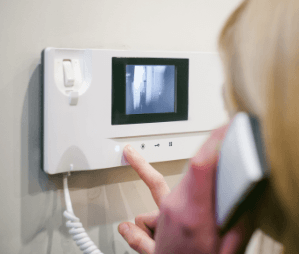 A woman is talking on a video intercom.