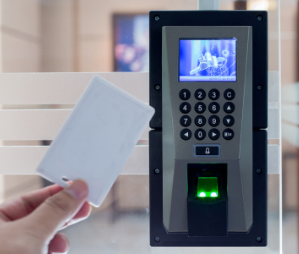 A person is holding a card in front of a fingerprint scanner