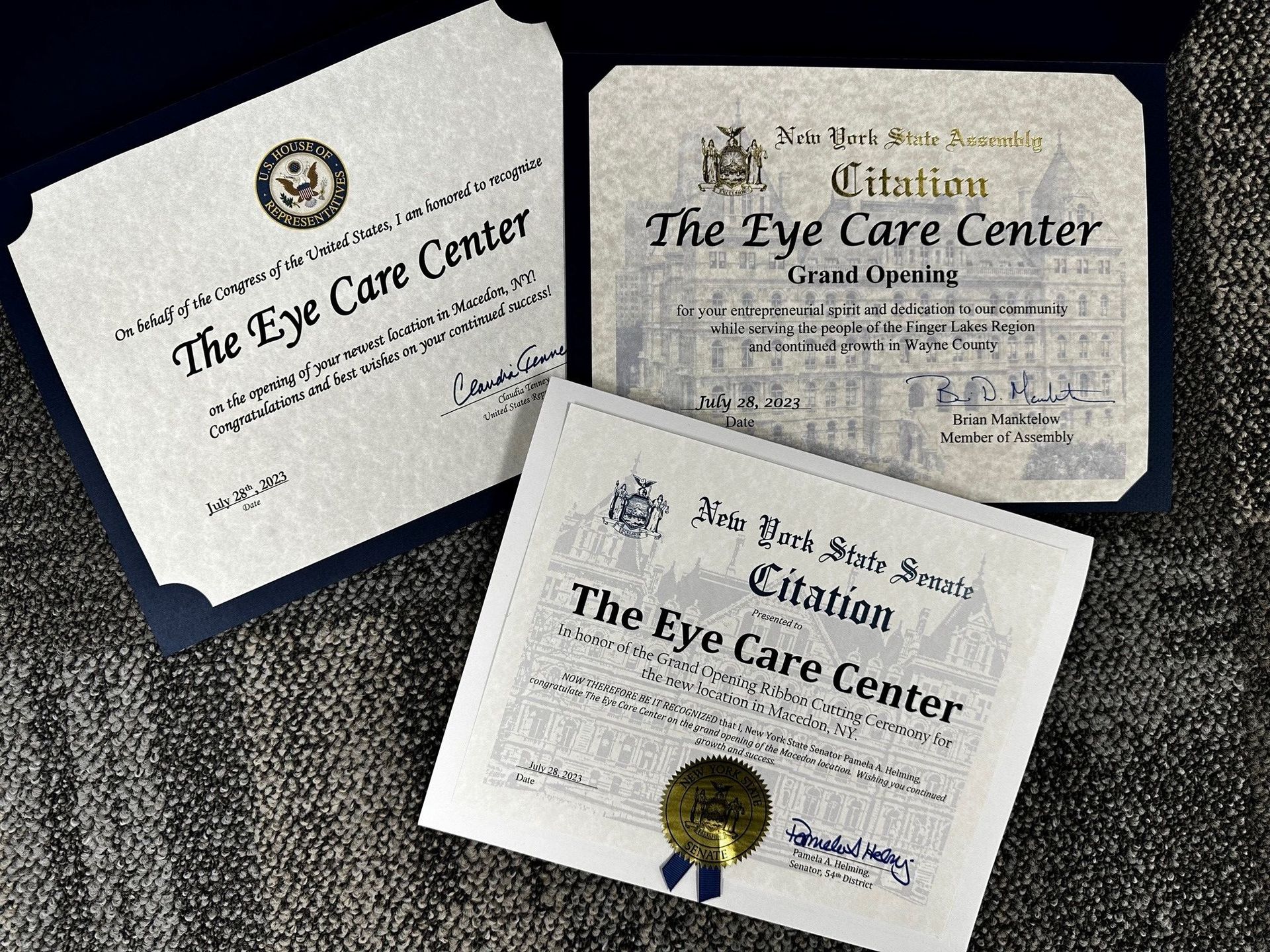 a group of 3 government-issued grand-opening certificates for The Eye Care Center