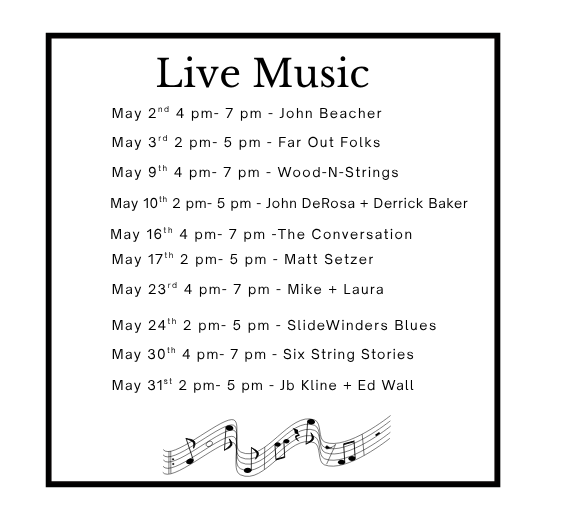 Hands decorating a Christmas wreath with dried fruit and greenery on a wooden table.