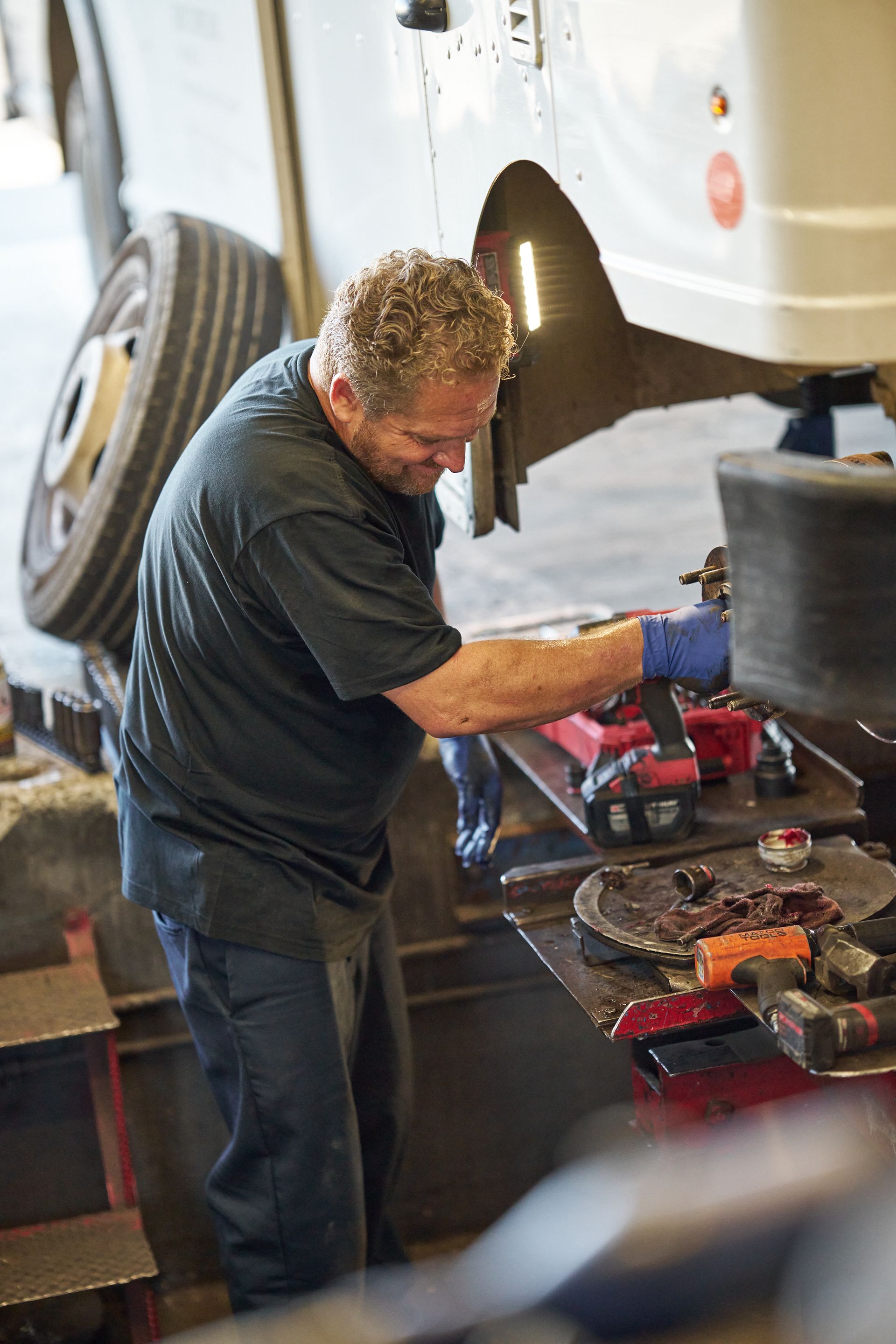 Mechanic working on a vehicle tire, using tools | Linville Brothers