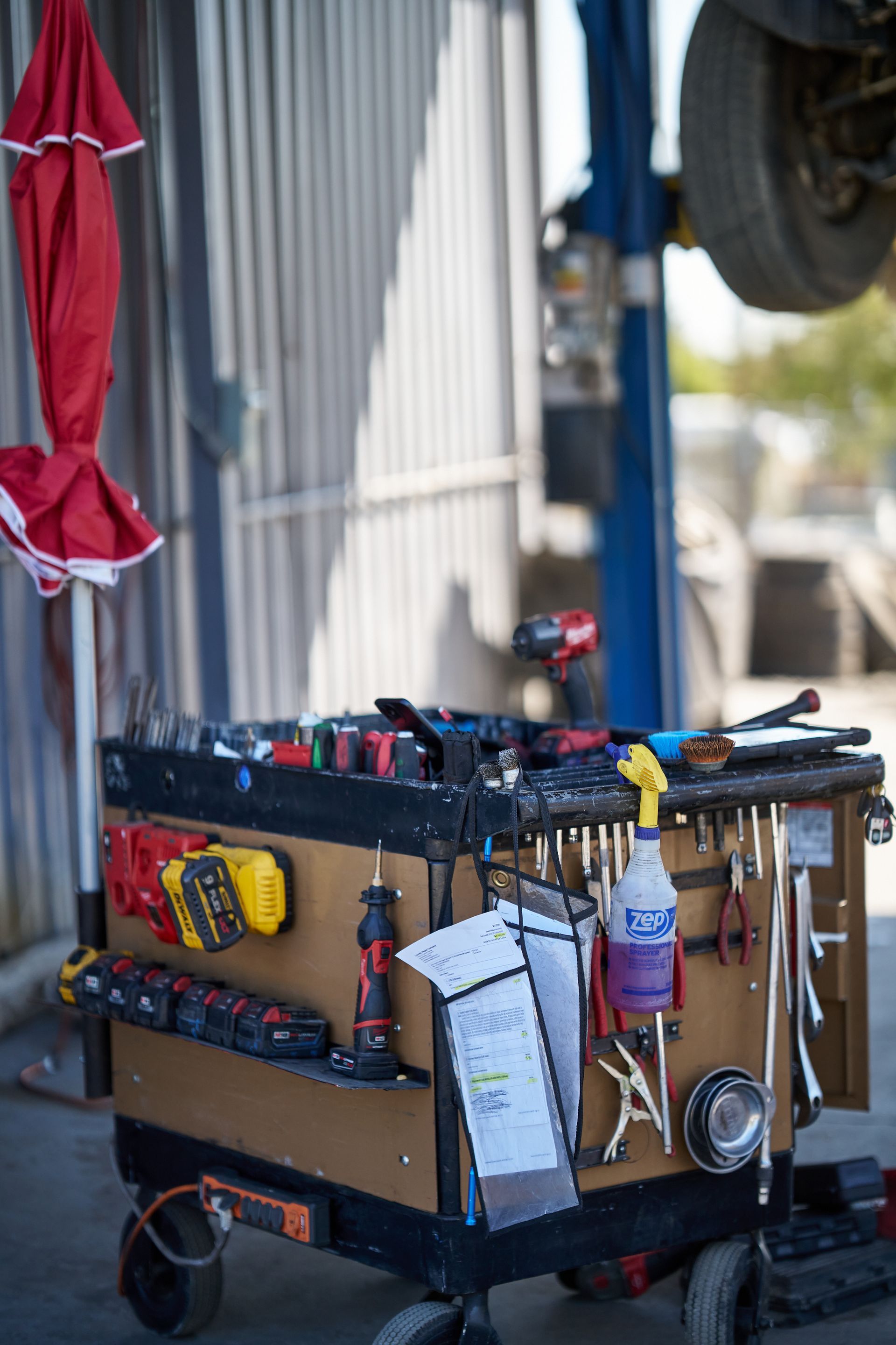 Mechanic's tool cart with assorted tools, near a car lift | Linville Brothers