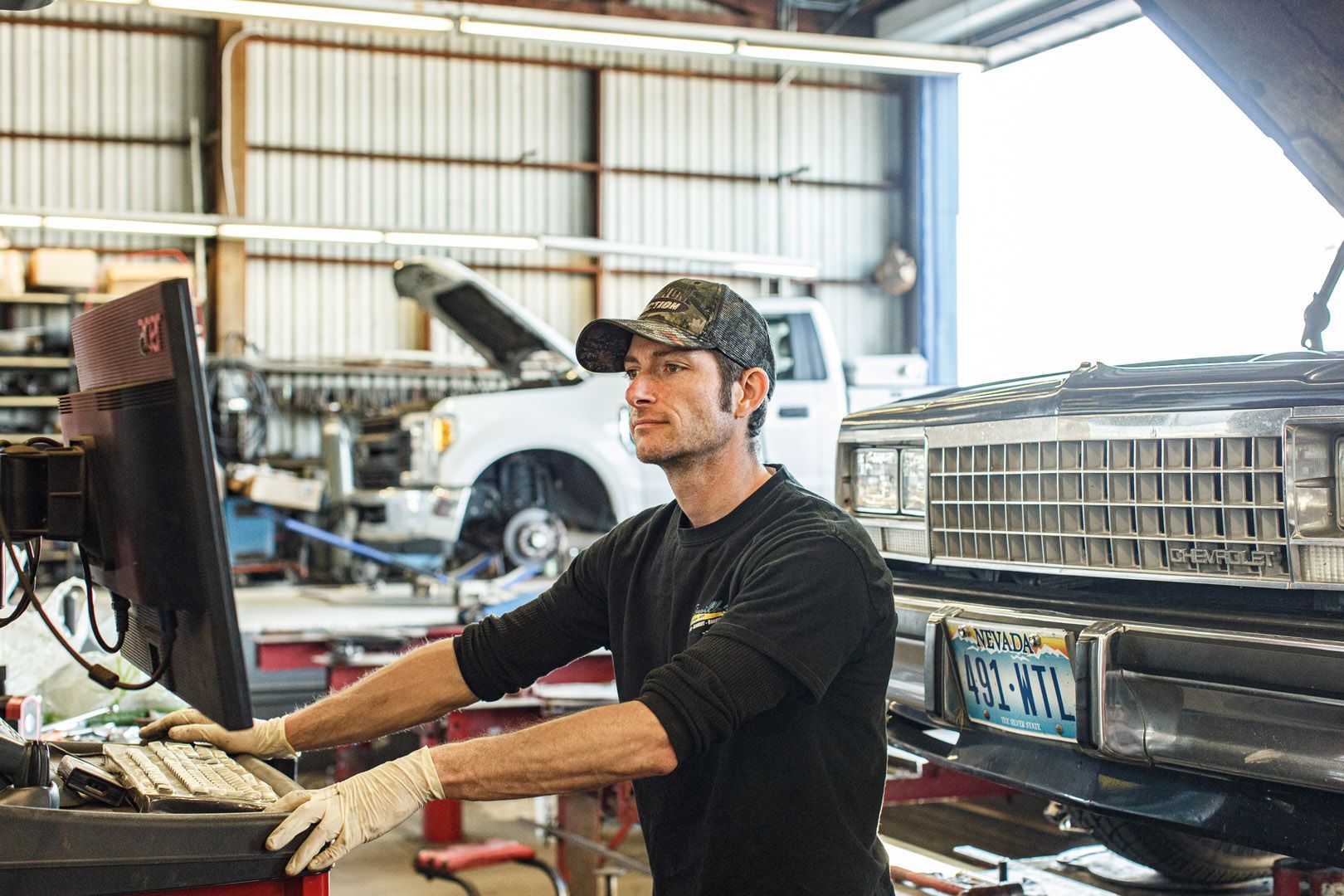 Auto Technician Operating Computer Beside Classic Car | Linville Brothers