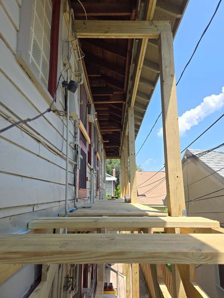 New wooden deck attached to a building, providing a covered walkway.