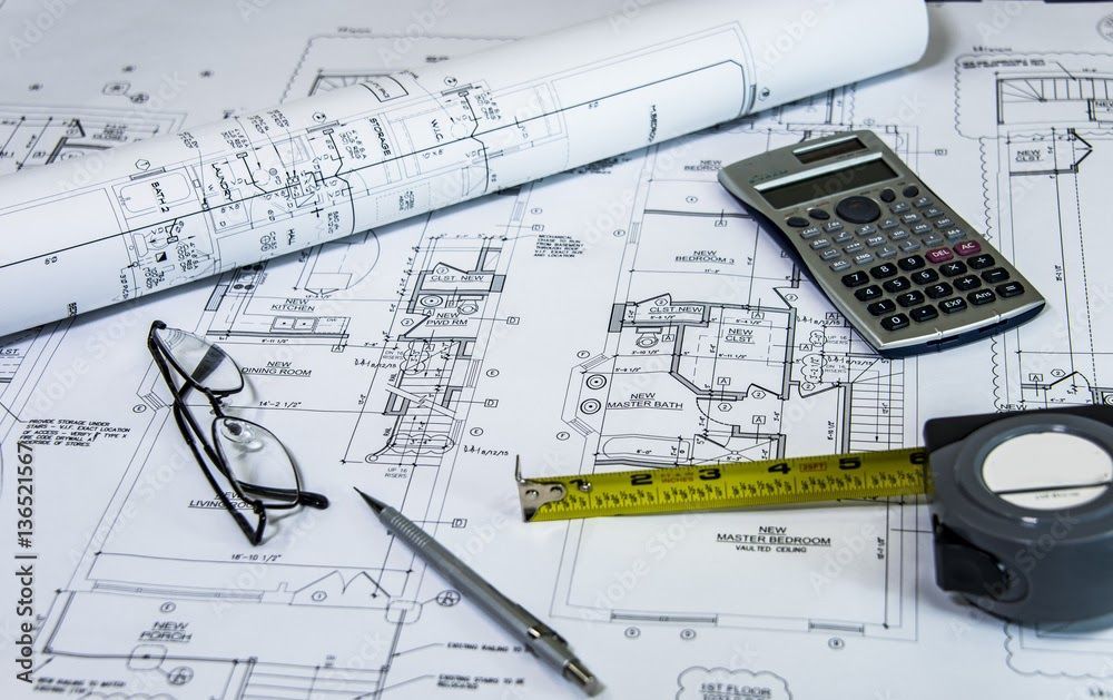Architectural blueprints with rolled-up paper and kitchen design details.