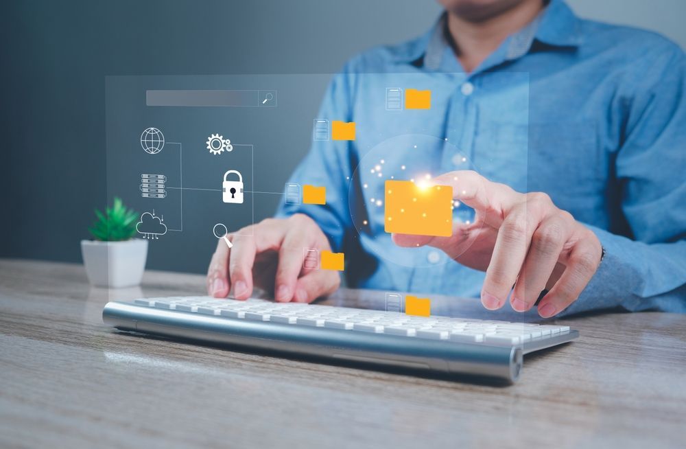 Person using a keyboard with digital file icons overlayed, symbolizing data management and security.
