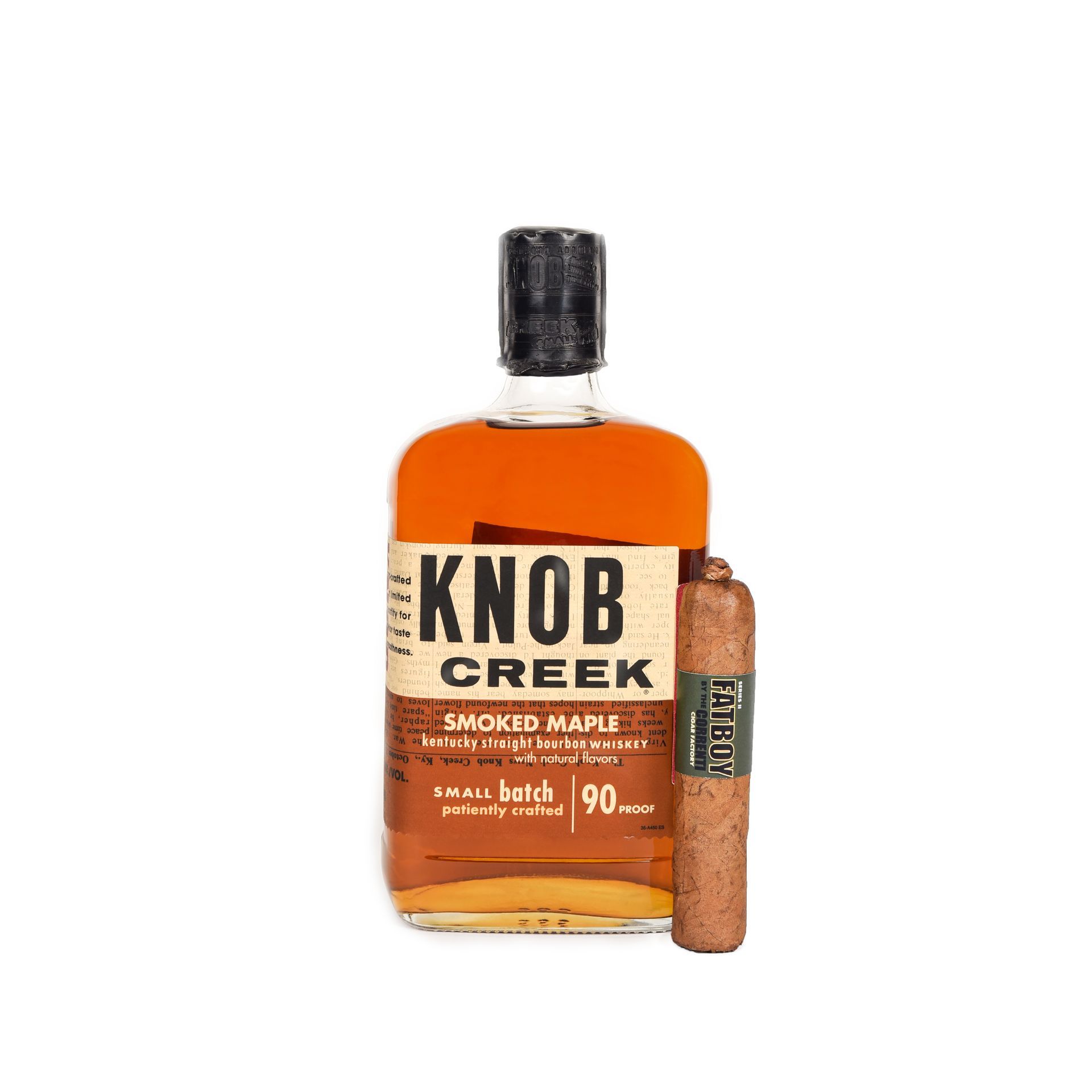 Knob Creek Smoked Maple bourbon bottle with cigar on a white background.