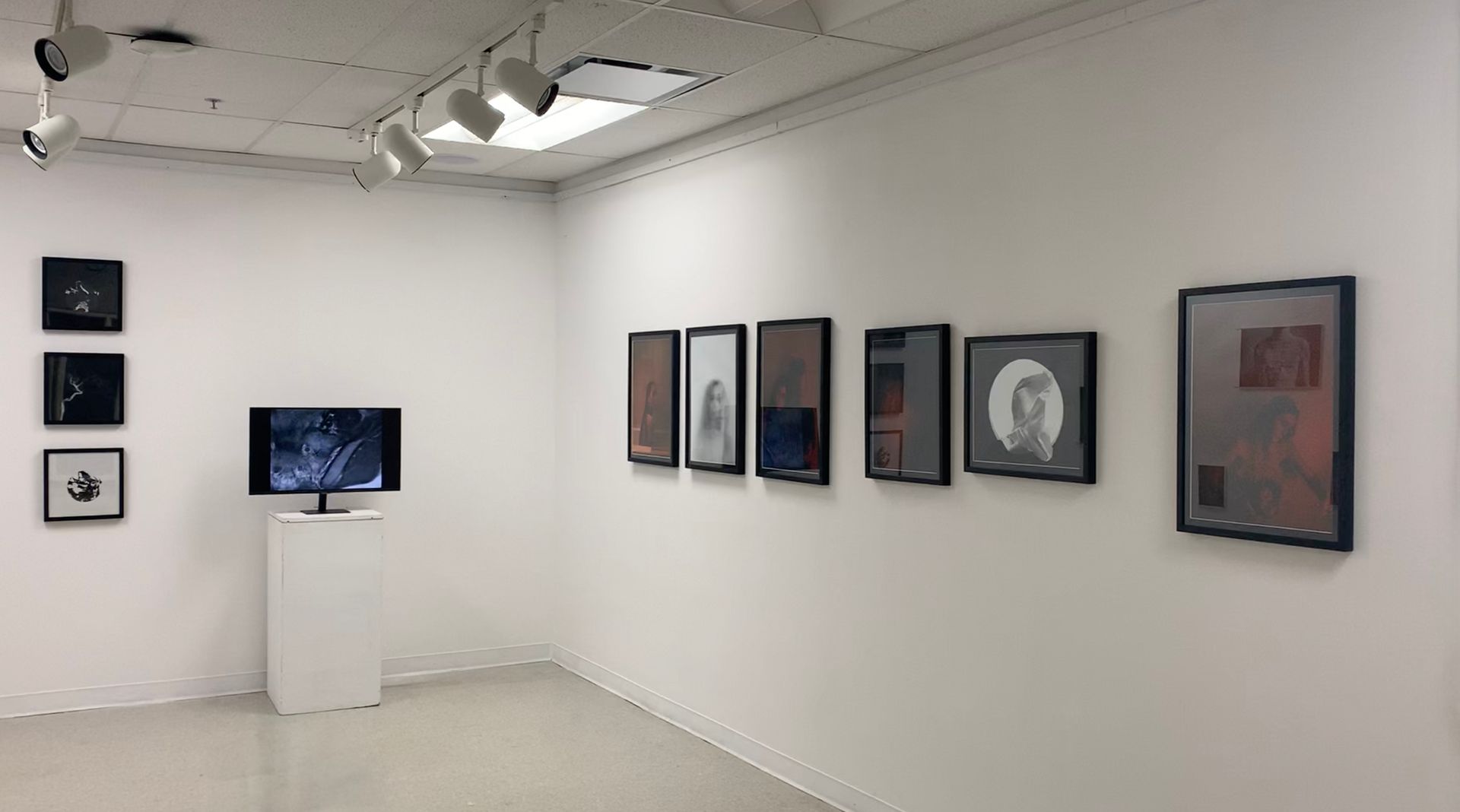 A room with a lot of pictures on the wall and a tv in on a stand.