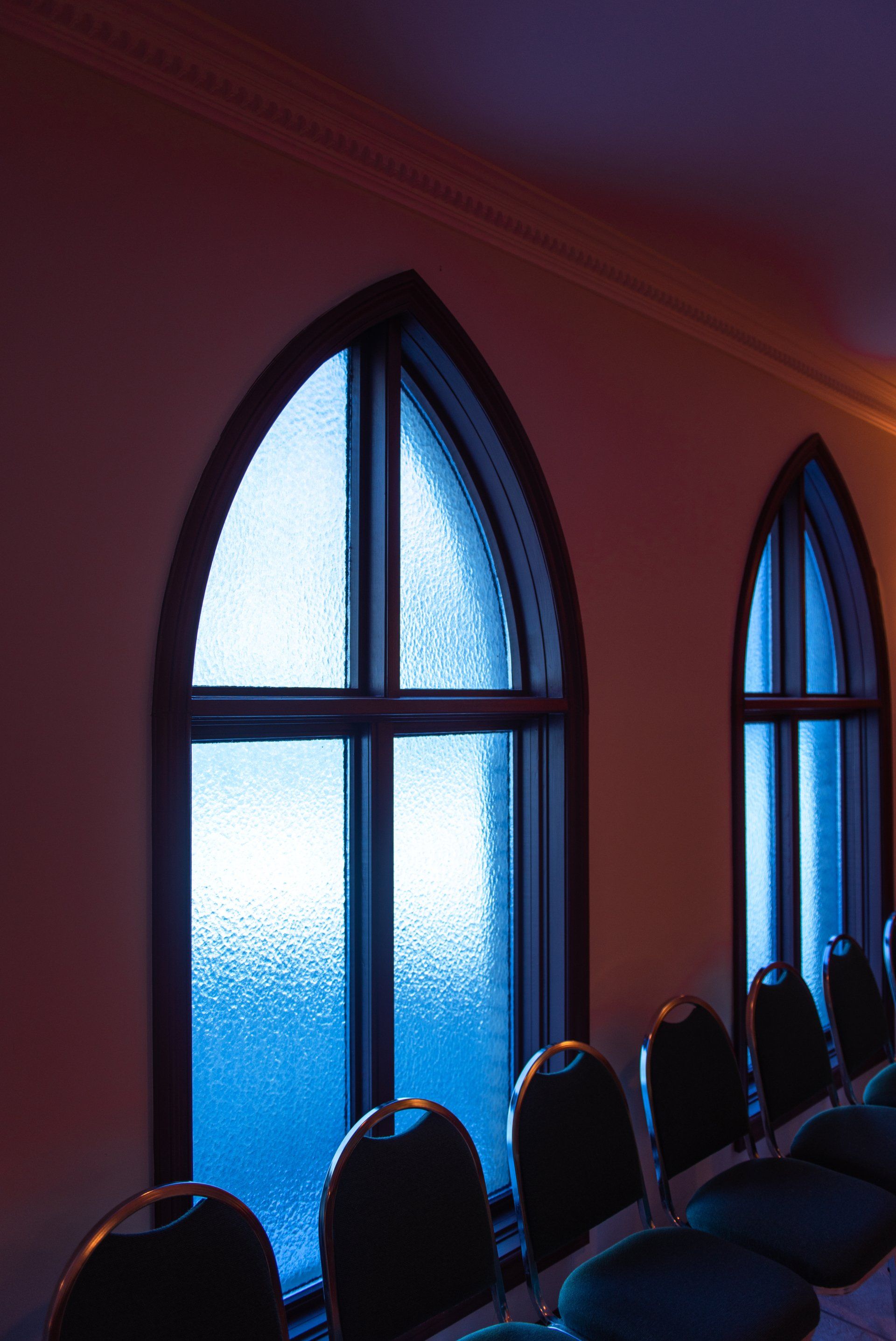 A row of chairs in front of arched windows.