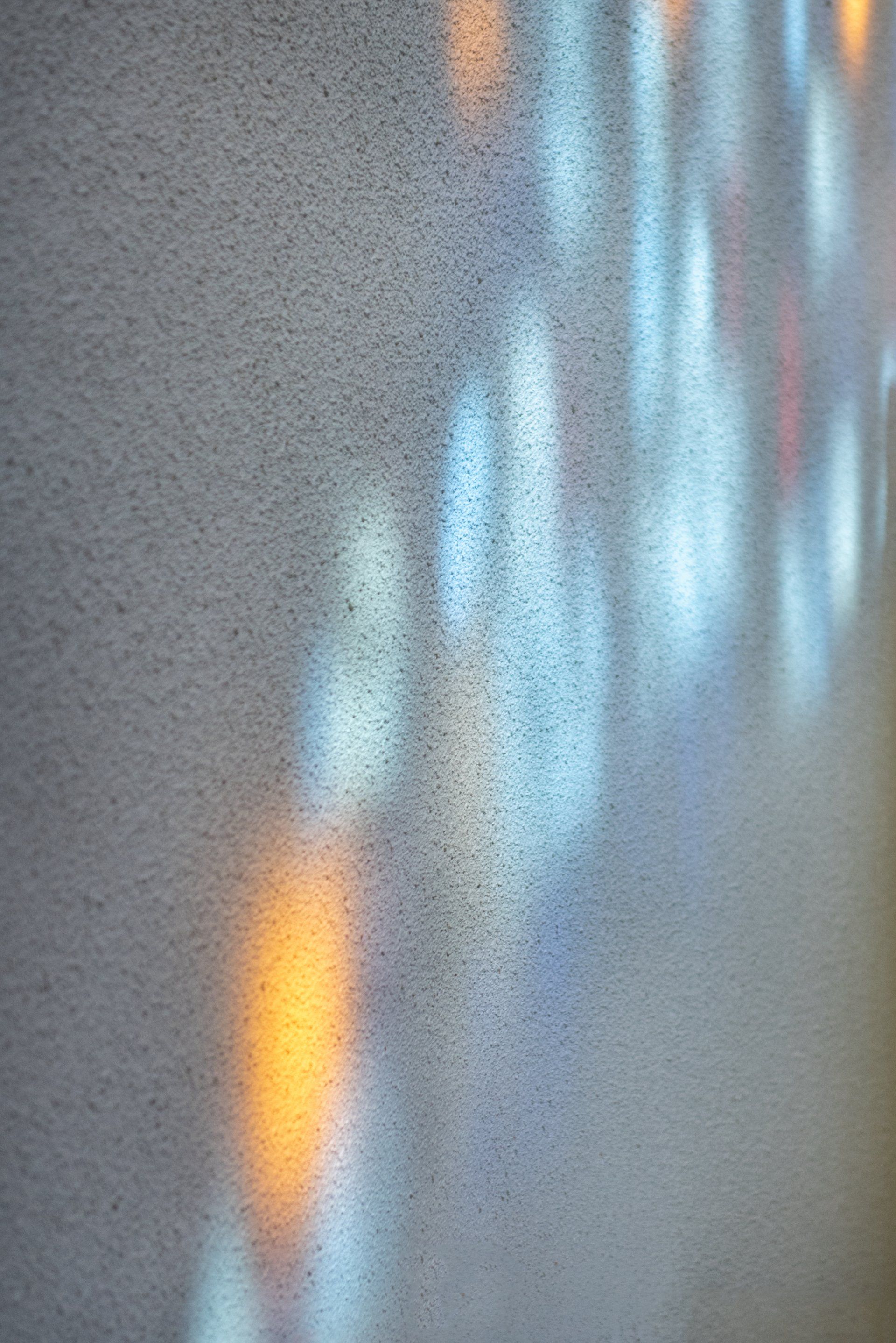 A close up of a wall with a shadow of a light on it.