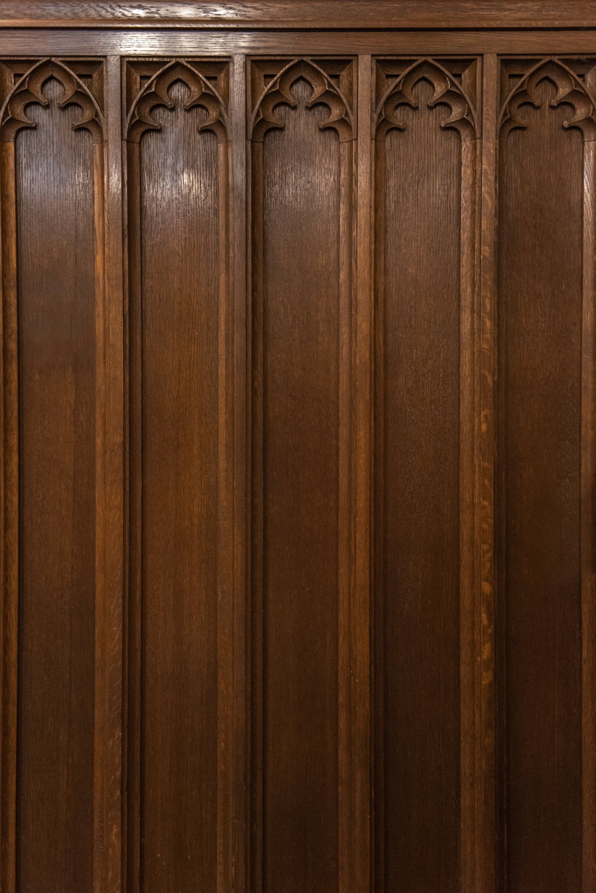 A close up of a wooden wall with carvings on it.